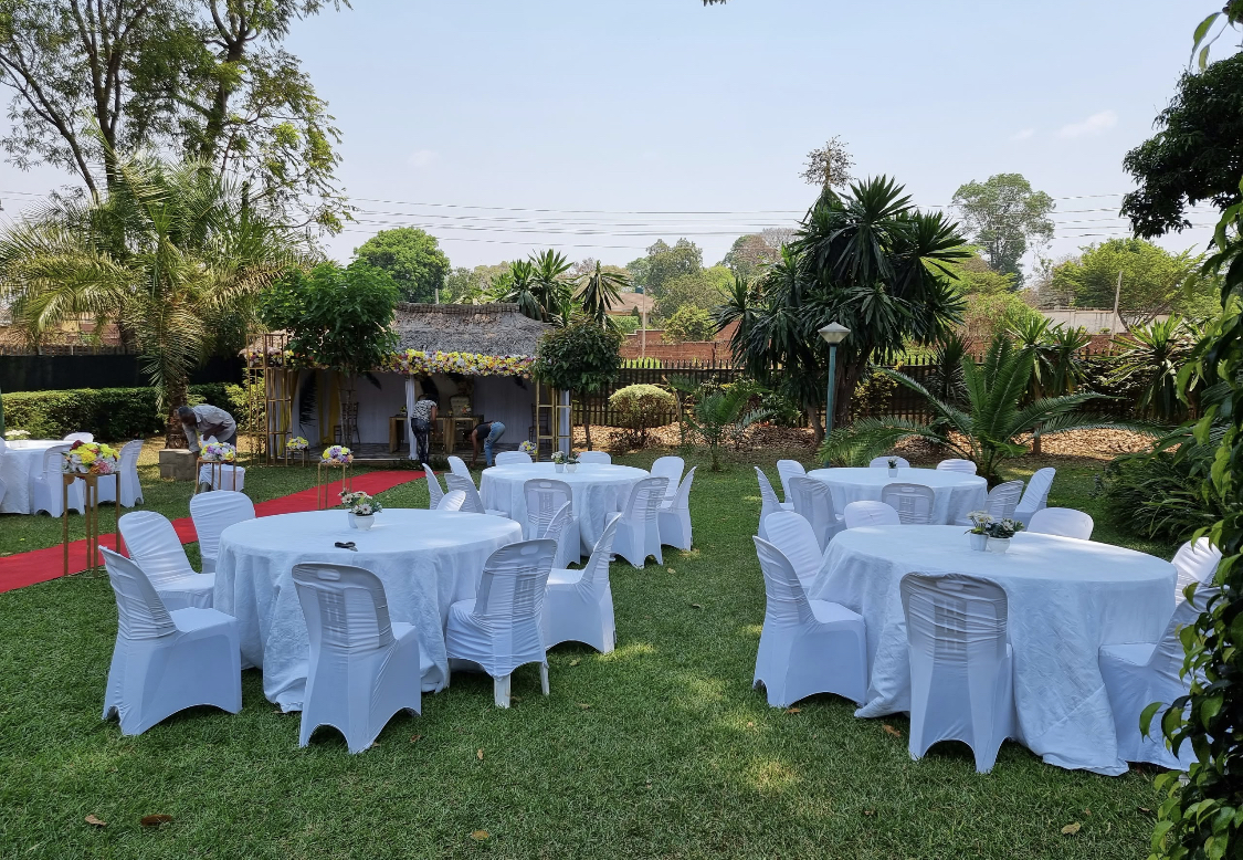 Garden set with white round tables and a red carpet for a private event